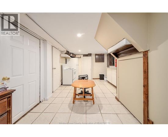 A kitchen area with a table and a refrigerator.