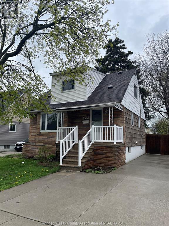 A house with a white porch and a brown roof.