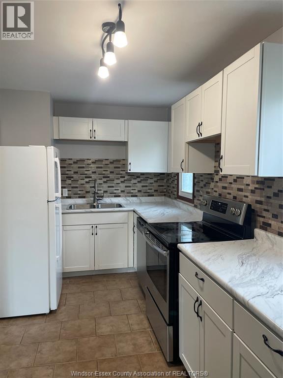 A kitchen with white appliances and cabinets.