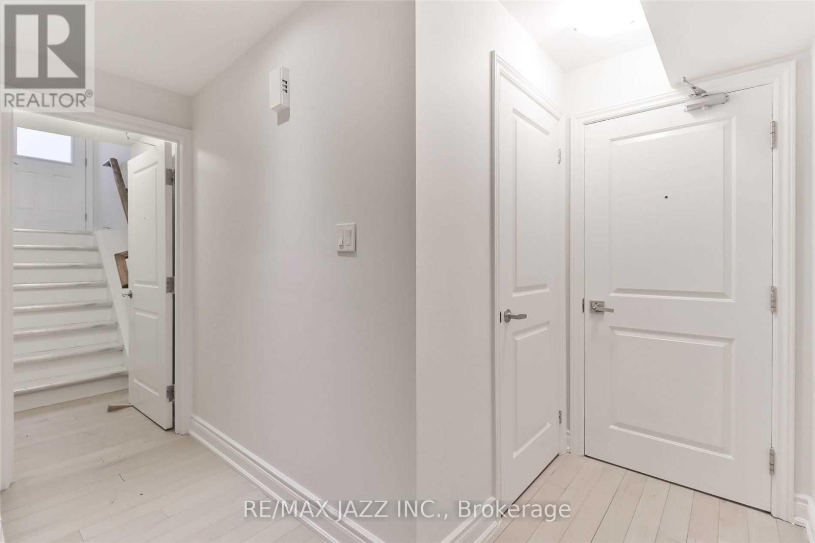 A white hallway with a brokerage sign on the wall.