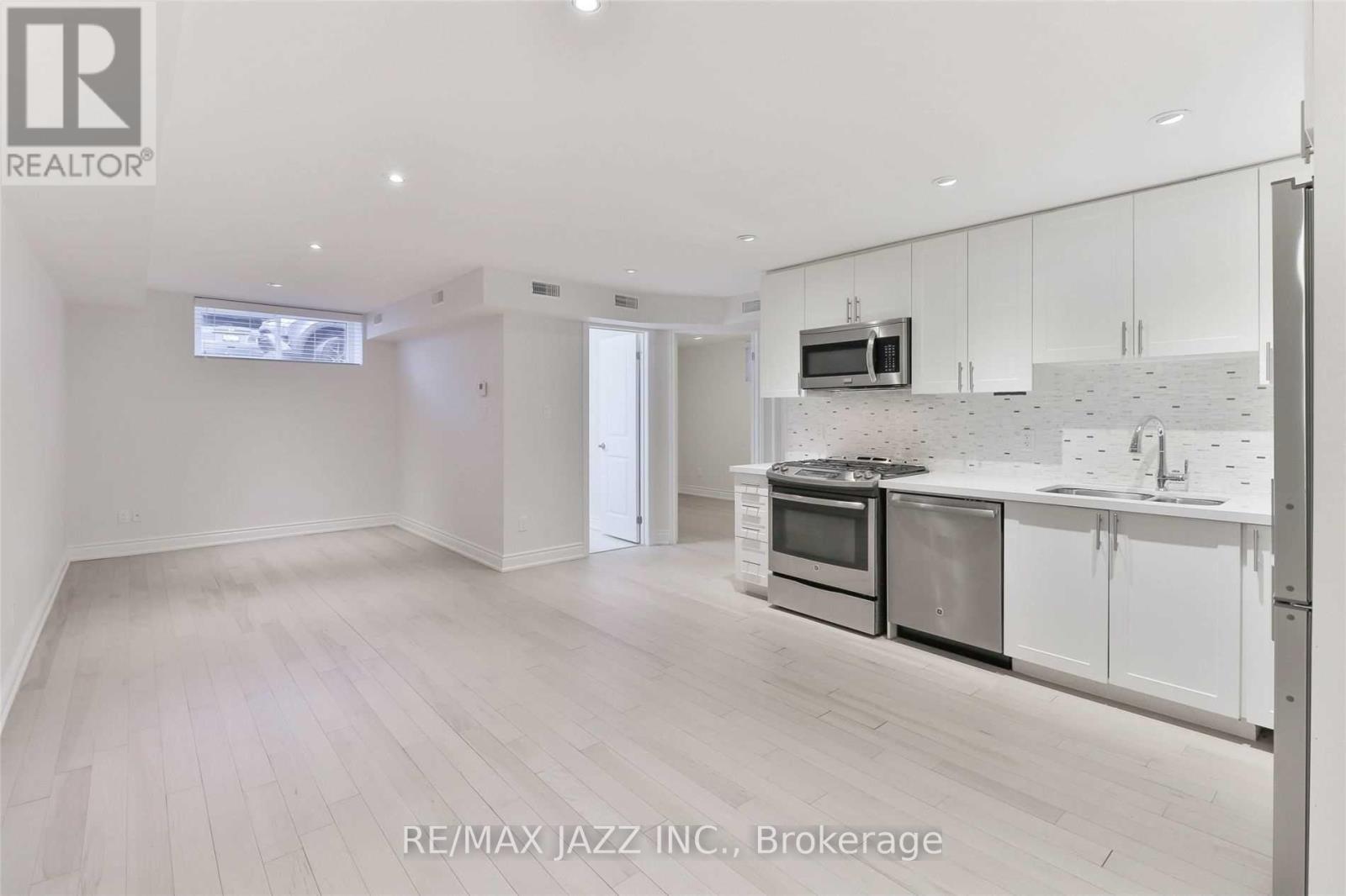 A spacious kitchen with white cabinets and stainless steel appliances.