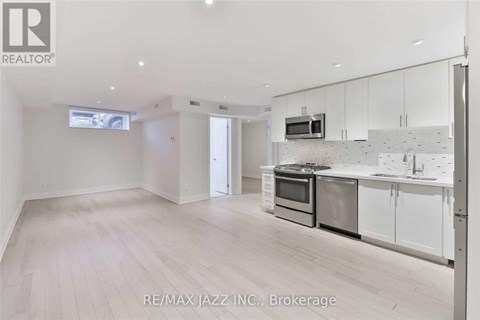 A spacious kitchen with white cabinets and stainless steel appliances.