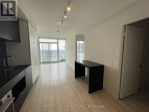 A real estate listing photo of a kitchen and living room.