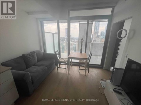 A living room with a grey couch and a wooden table.