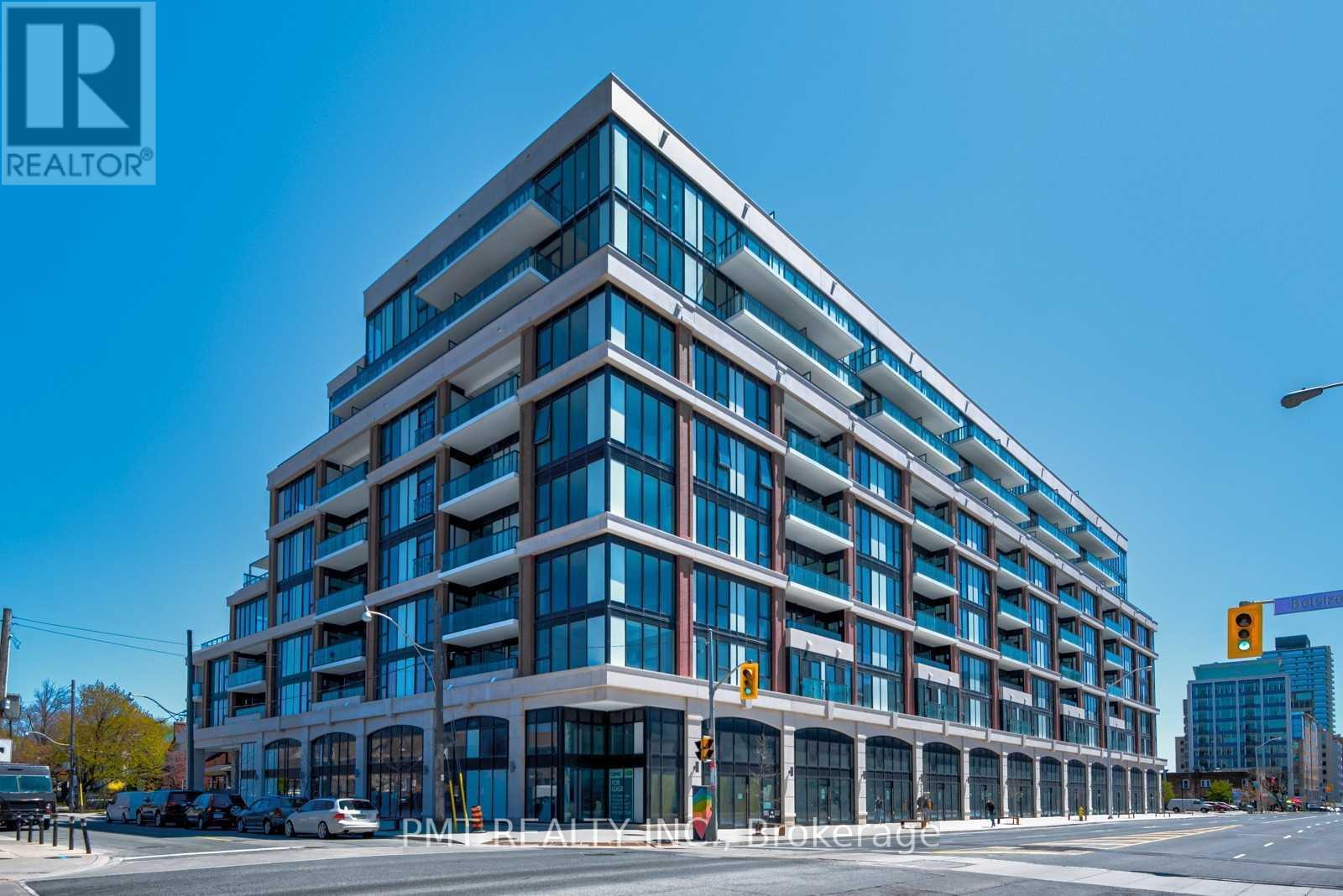 A modern multi-story building with a glass facade and a REALTOR® logo on the top left corner.