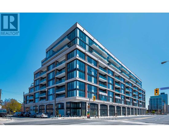A modern multi-story building with a glass facade and a REALTOR® logo on the top left corner.