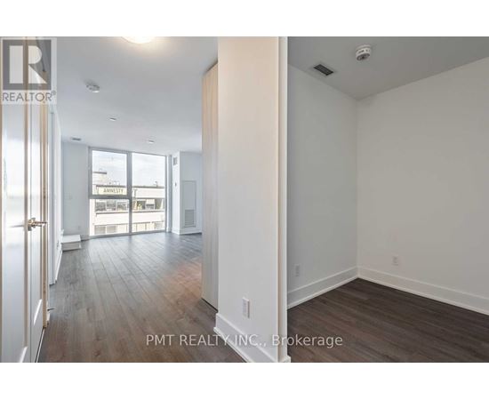 A well-lit, spacious room with wood flooring and white walls.