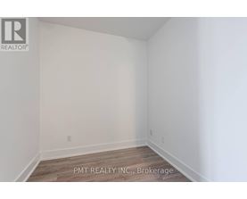 A white room with a wooden floor and a wall socket.