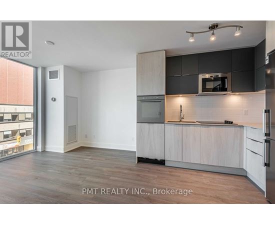 A kitchen with white cabinets and a black countertop.
