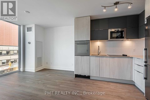 A kitchen with white cabinets and a black countertop.