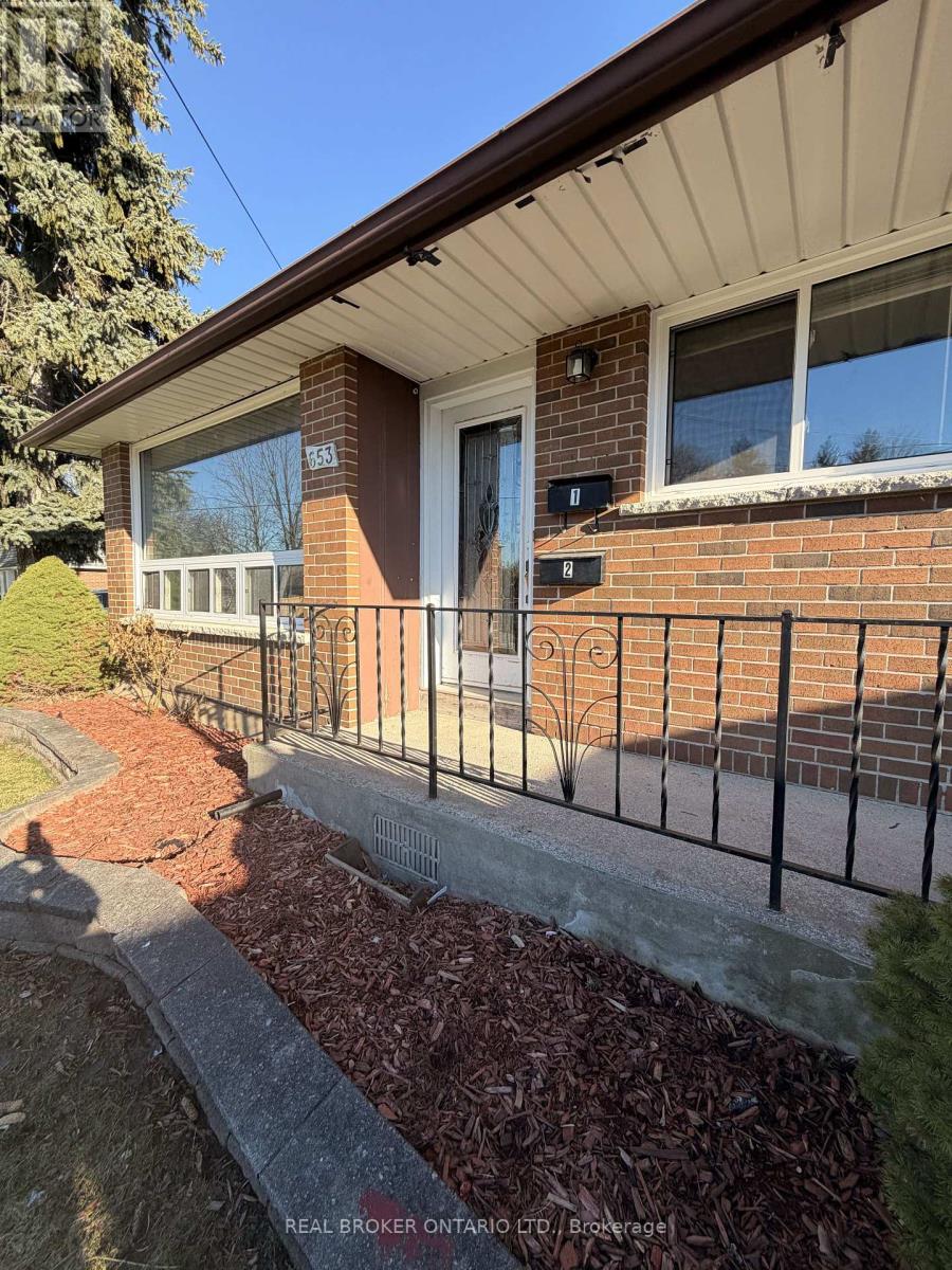 A house with a brick wall and a black metal fence.