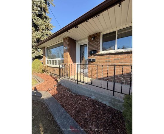 A house with a brick wall and a black metal fence.