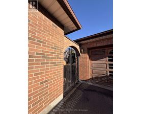A brick wall with a gate and a window.