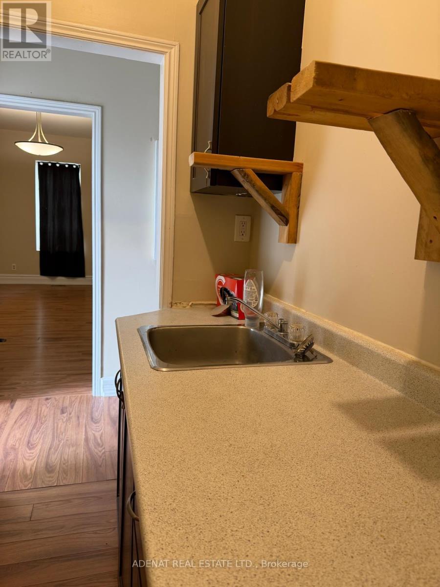 A kitchen with a sink and a mirror above it.