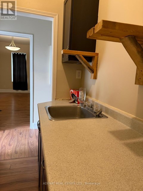 A kitchen with a sink and a mirror above it.