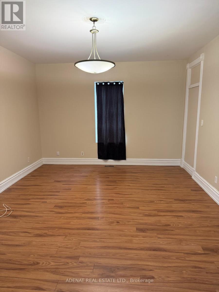 A room with wooden flooring and a black curtain.