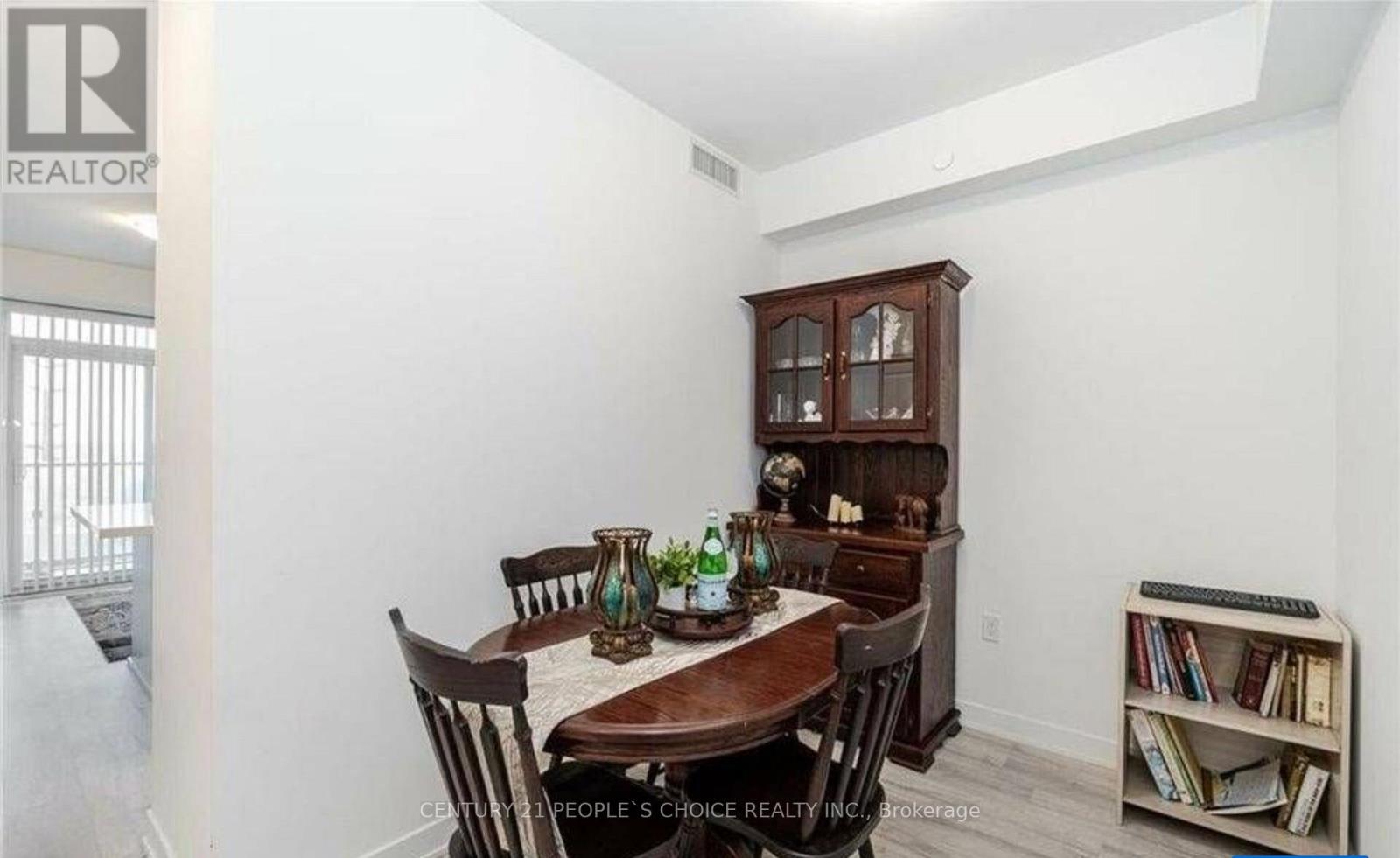 A dining room with a wooden table and chairs.