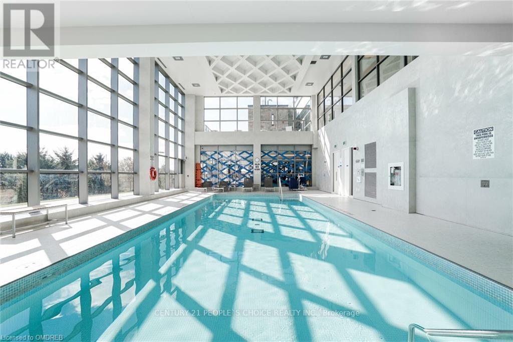 A large indoor swimming pool with a glass wall on one side.