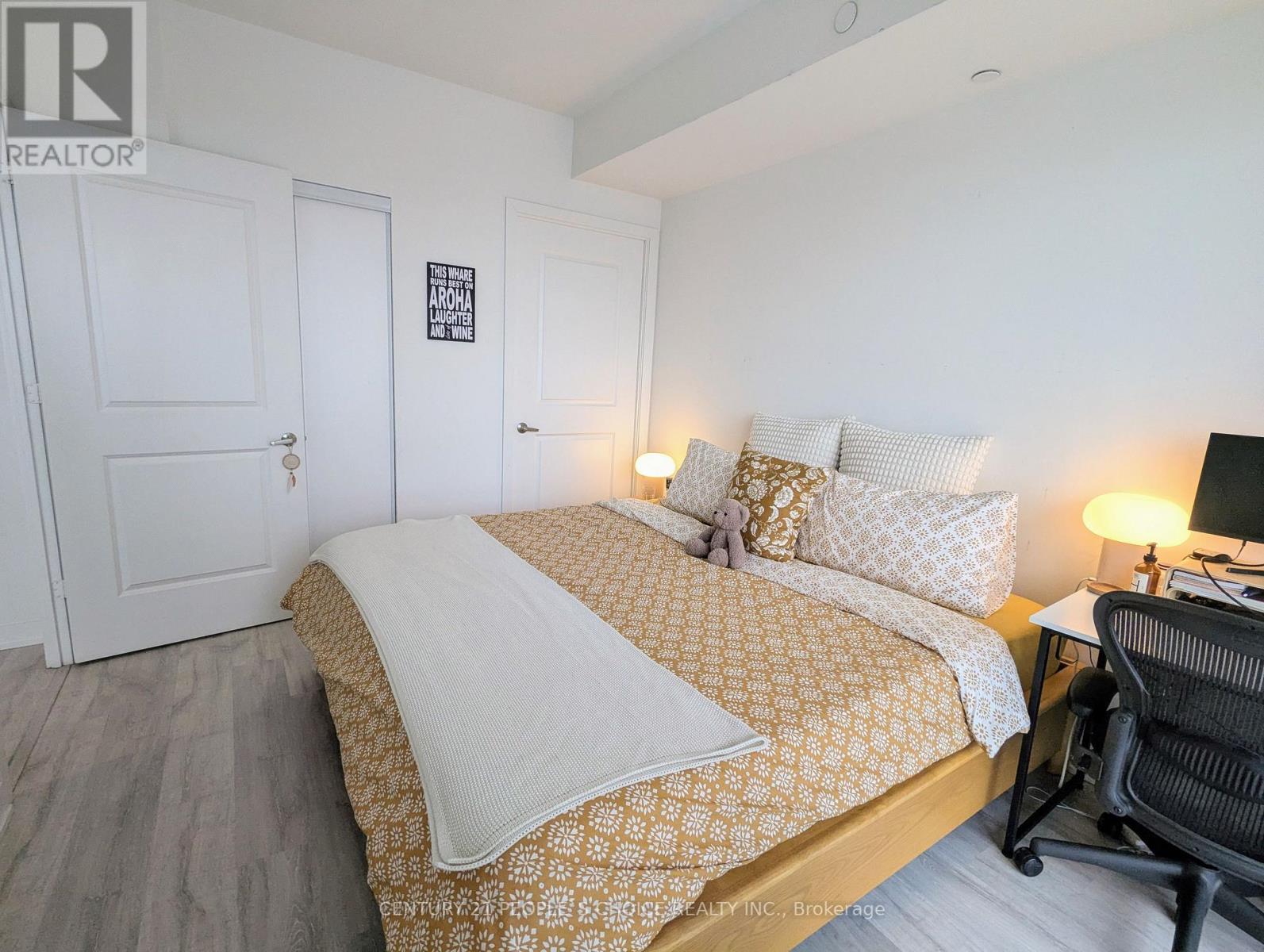 A bedroom with a bed, desk, and chair.