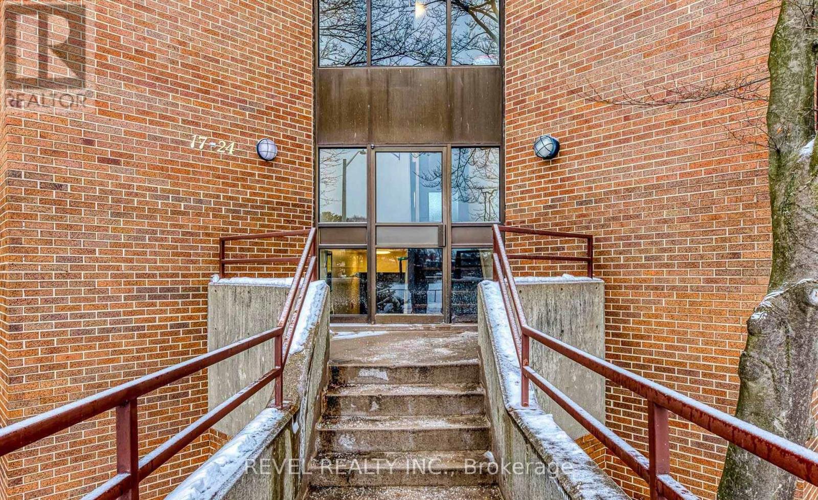 A staircase with a metal railing leads to a glass door.