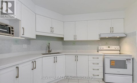 A kitchen with white cabinets and appliances.