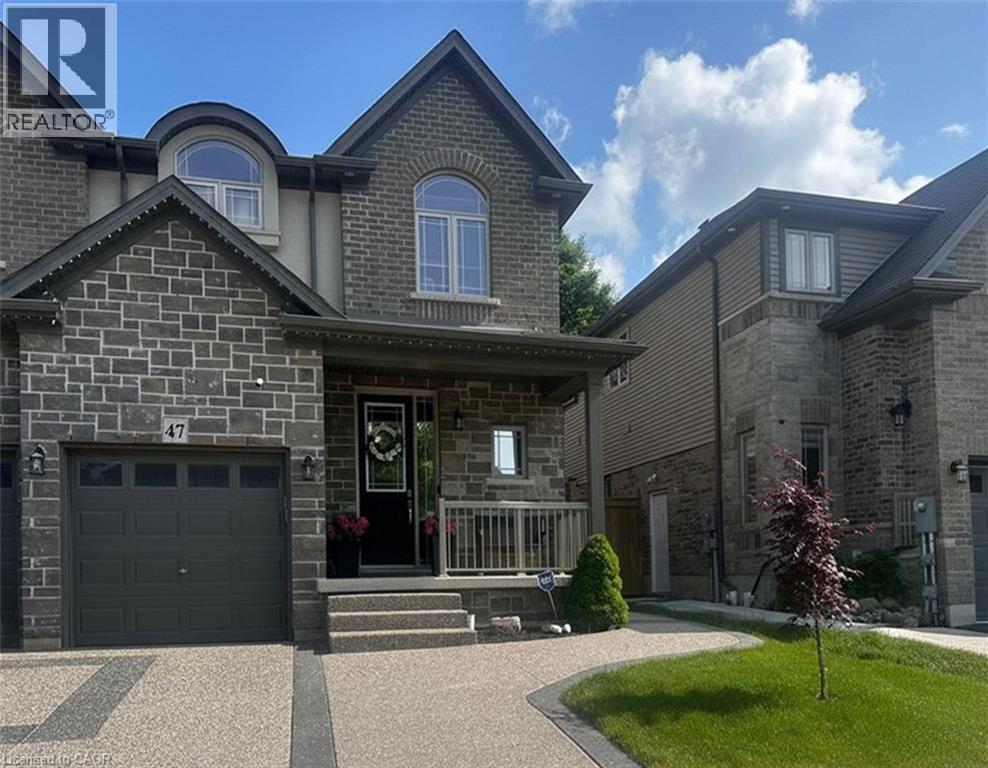 A large house with a stone facade and a driveway in front.