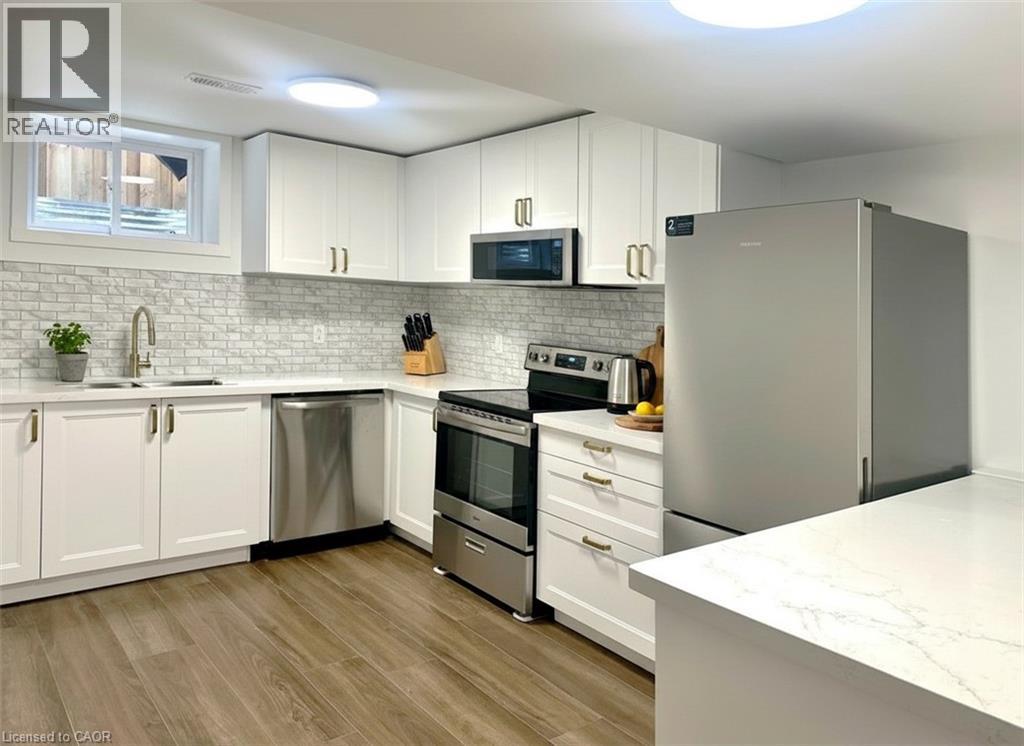 A modern kitchen with white cabinets and stainless steel appliances.