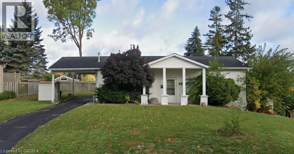 A white house with a black roof and a small porch.