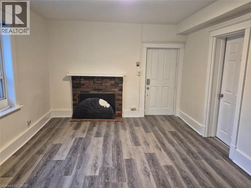 A room with a fireplace and wooden flooring.