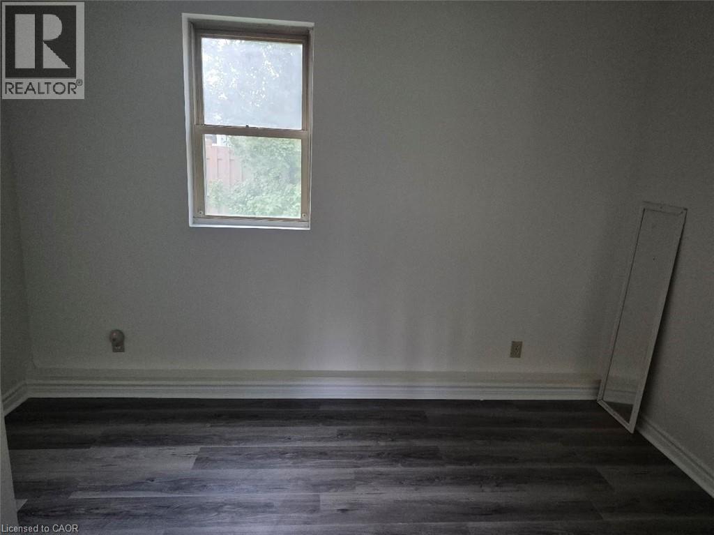 A room with a window and a wooden floor.