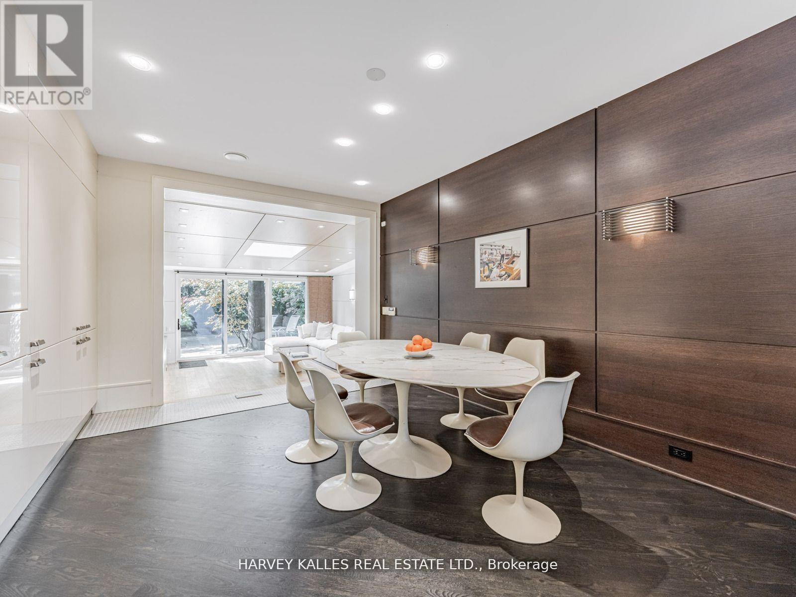 A modern dining room with a white table and chairs.