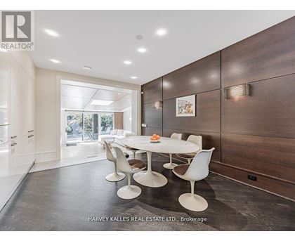 A modern dining room with a white table and chairs.