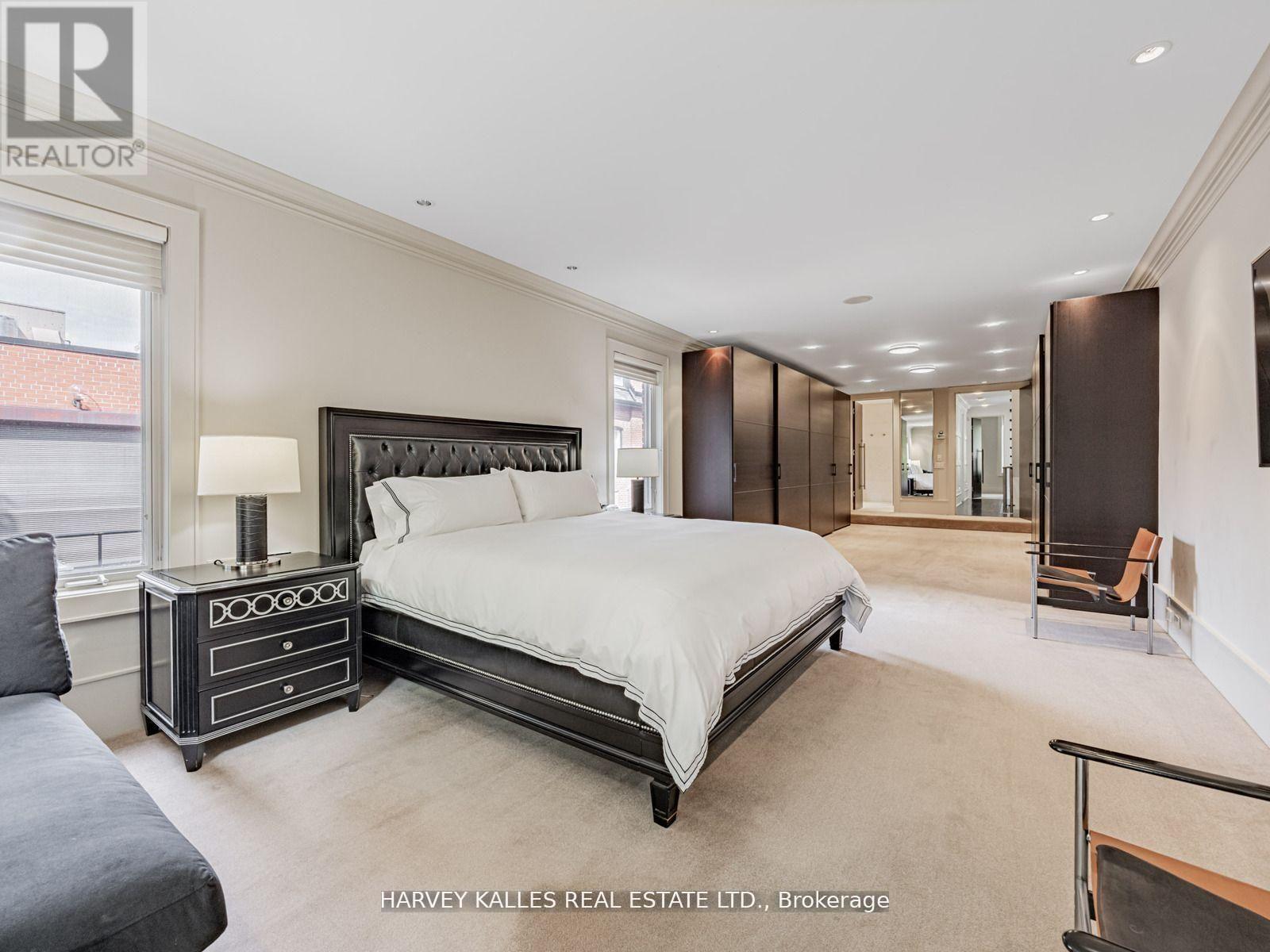 A bedroom with a large bed and a nightstand with a lamp.