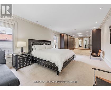 A bedroom with a large bed and a nightstand with a lamp.