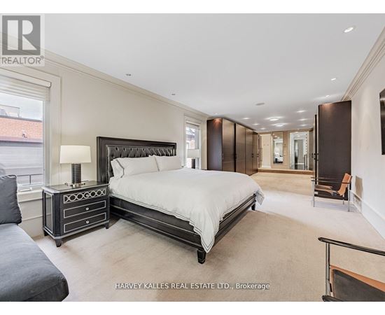 A bedroom with a large bed and a nightstand with a lamp.