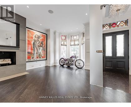 A motorcycle is parked in a spacious room with a fireplace and a large painting on the wall.