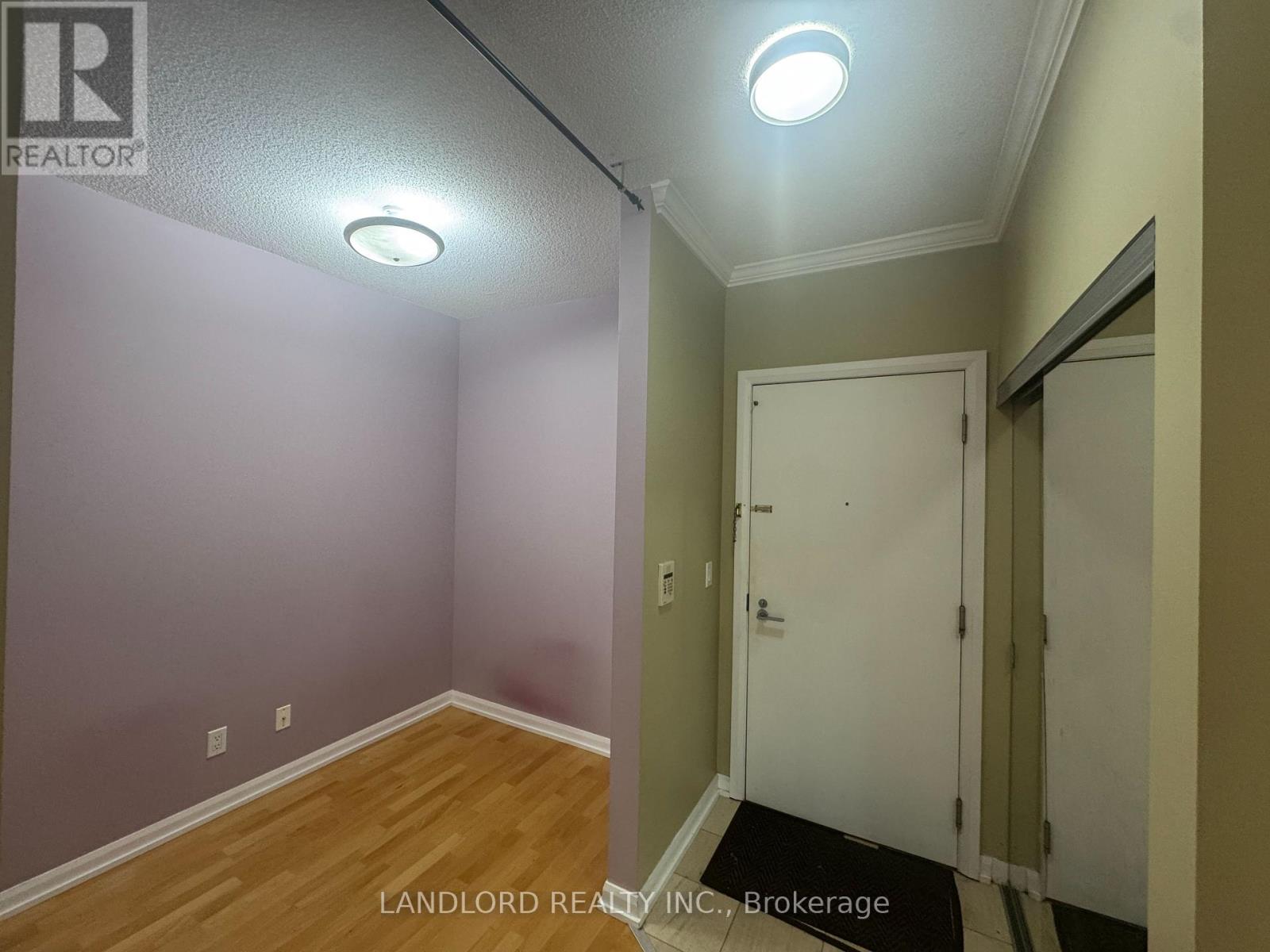 A room with a white door and a light on the ceiling.