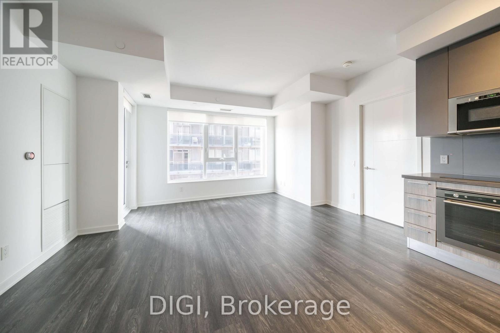 A spacious kitchen with a modern design featuring a stainless steel oven and microwave.
