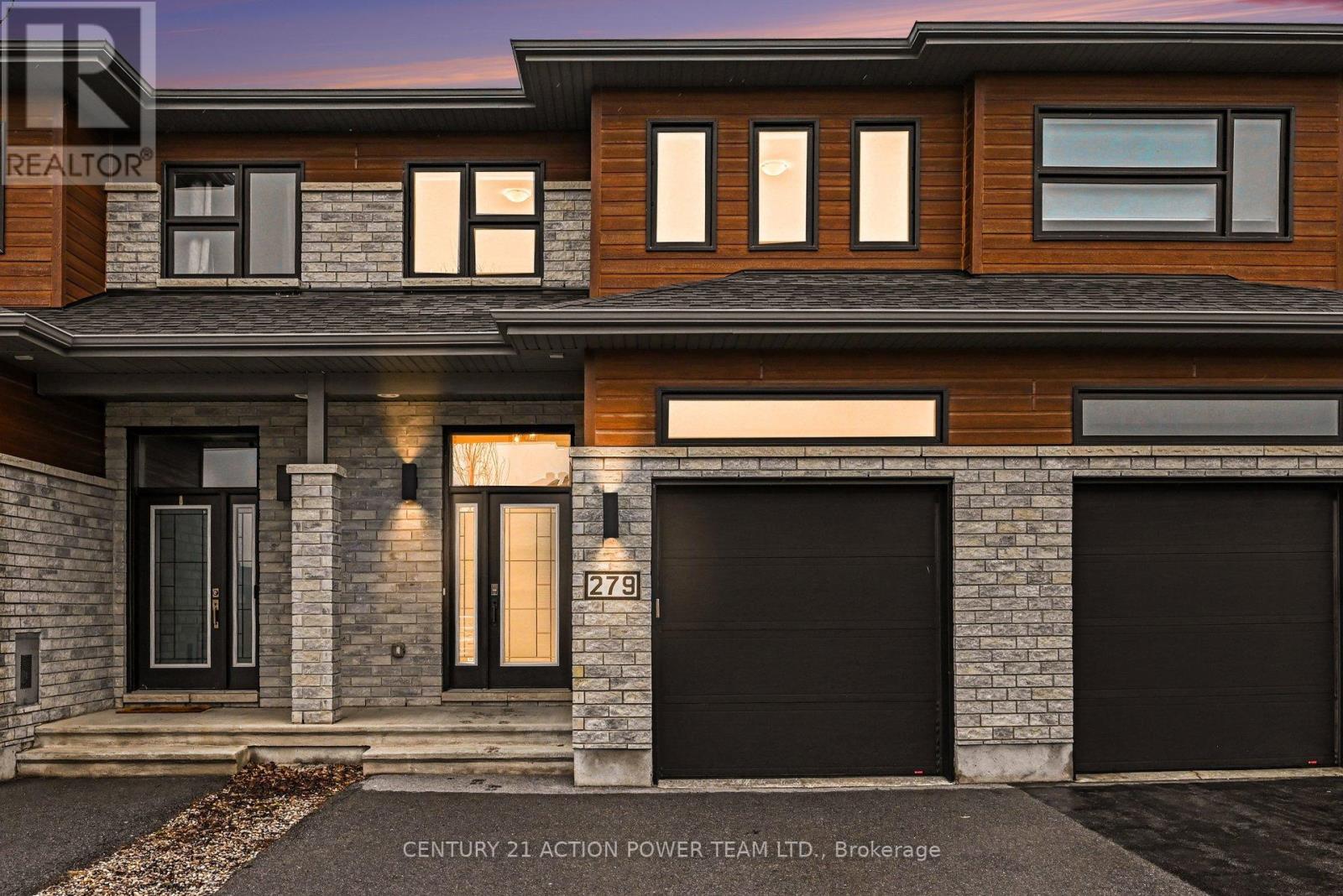 A modern house with a black front door and garage doors.
