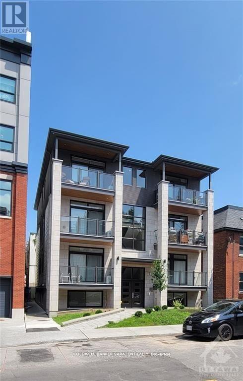 A modern apartment building with a black car parked in front.