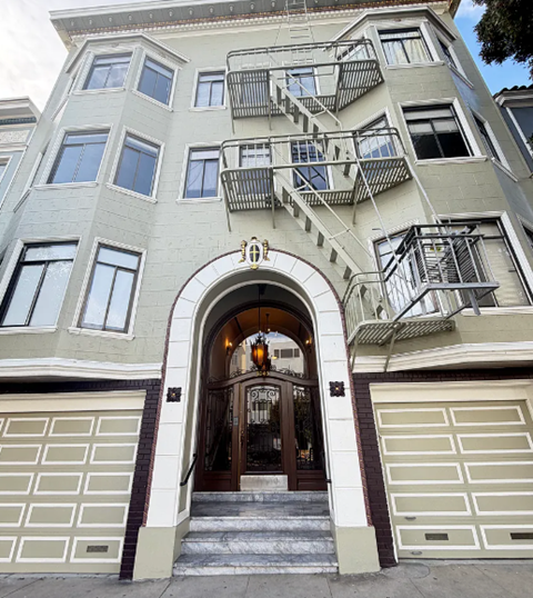 A building with a staircase on the side and a garage door.