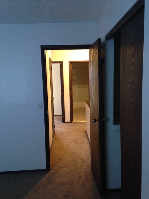 A hallway with a door open to another room.