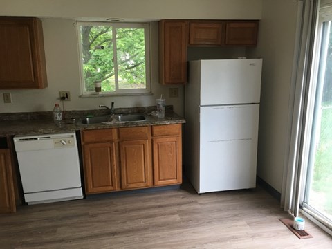 A kitchen with a white fridge and a white dishwasher.