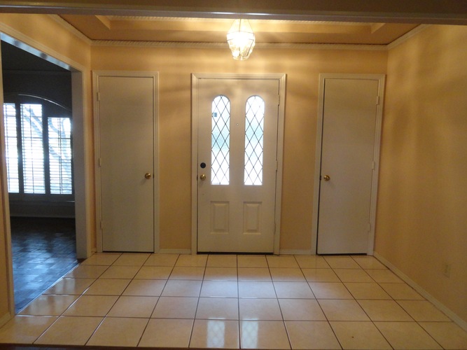 A room with three doors and a window.