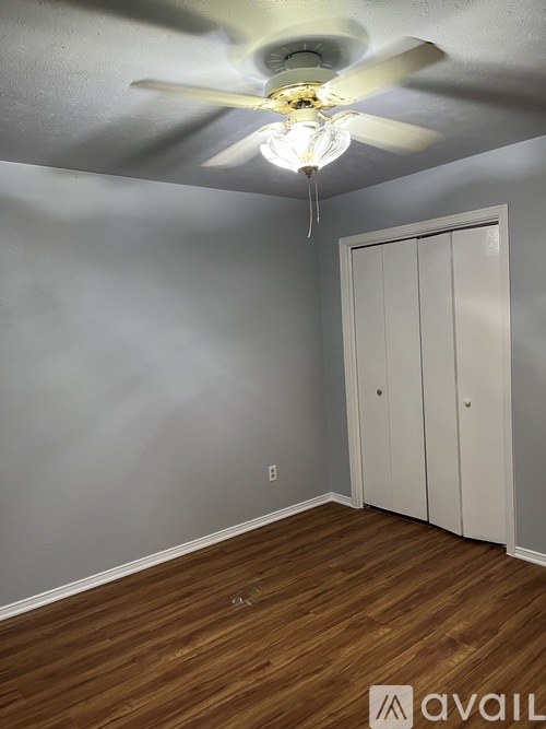 A room with a ceiling fan and a white door.