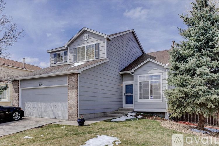 A house with a garage and a driveway in front of it.