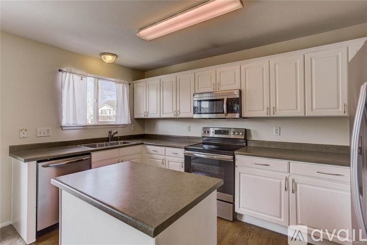 A kitchen with white cabinets and a stainless steel island.