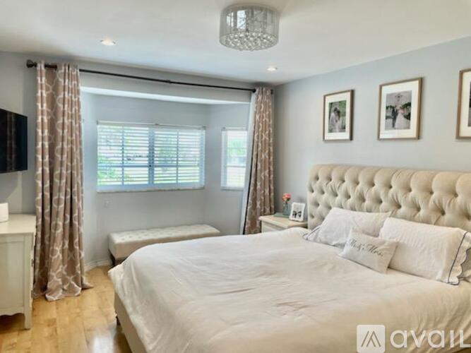 A bedroom with a large bed and a chandelier.
