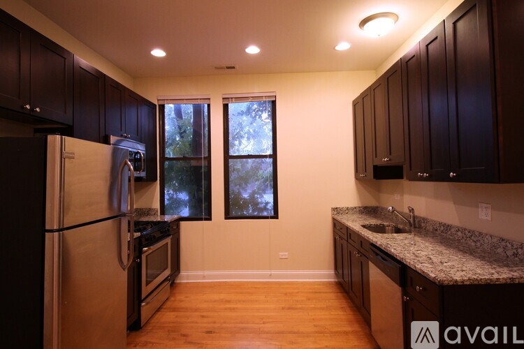A kitchen with wooden floors and dark brown cabinets.
