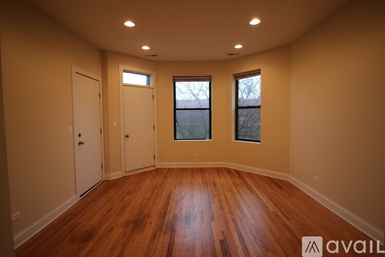 A room with wooden floors and two windows.
